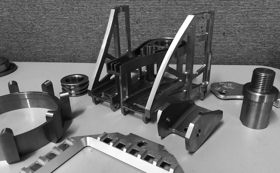 Finished CNC-machined aerospace parts on a shop table
