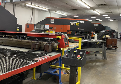 CNC punch press and sheet-metal handling equipment on the shop floor
